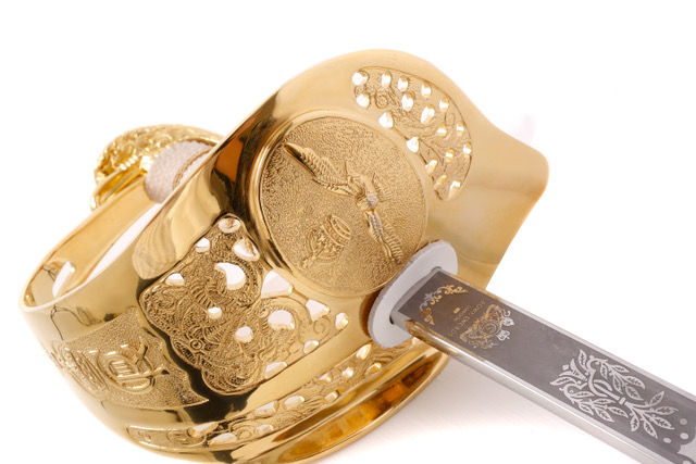 A ceremonial sword and gold decorated helmet
